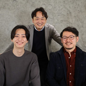 3人。一人後ろに立ち、前に二人座っている姿