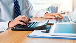 Businessman working with digital tablet and laptop in office room.