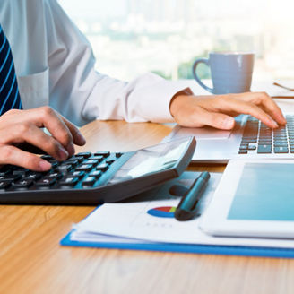 Businessman working with digital tablet and laptop in office room.