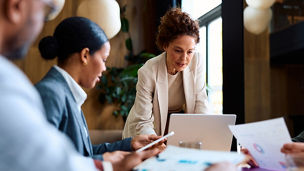 Group of diverse business people meeting in an office setting, working together, discussing important corporate strategies and analyzing financial reports