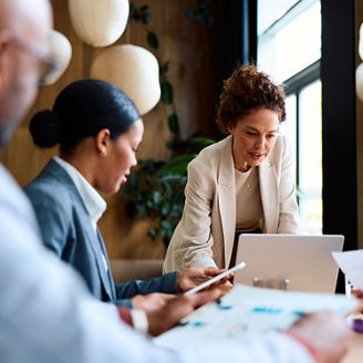 Group of diverse business people meeting in an office setting, working together, discussing important corporate strategies and analyzing financial reports