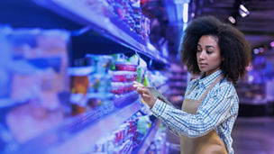 Japanese alt text: 商品棚を見る女性