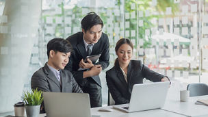 Young asian business people meeting and planning business strategies together in the office.
