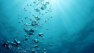 Bubbles undersea and sun rays.