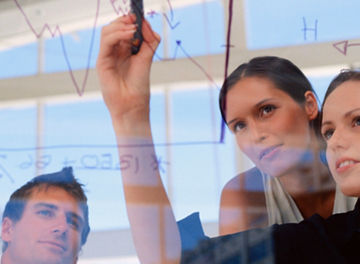 Businesswoman drawing graphs on glass