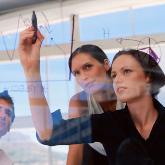 Businesswoman drawing graphs on glass