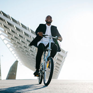 Spain, Barcelona. African american businessman relaxing after work. Using the bike.