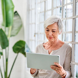 Cropped shot of a senior businesswoman standing alone in her office and using her tablet