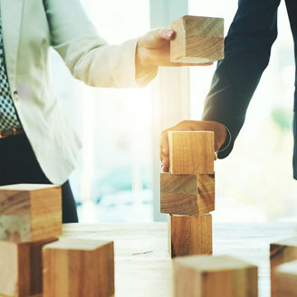  積み木を重ねる2人の人物