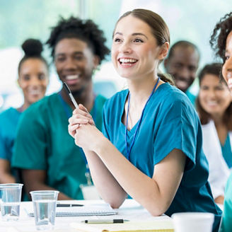 Cheerful Hispanic female nursing students smiles as she listens to a professor's lecture.