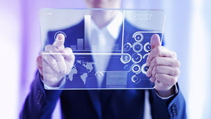 透明なタブレットでグラフを見るひと