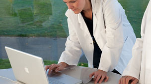 コンピュータで作業中の医者