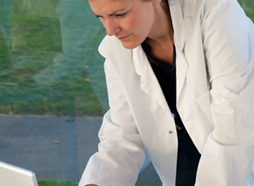 コンピュータで作業中の医者