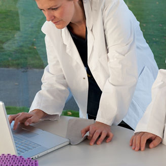 コンピュータで作業中の医者