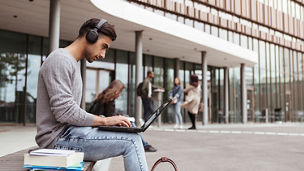 ノートPCを使いながら音楽を聴く学生