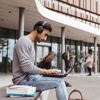 ノートPCを使いながら音楽を聴く学生