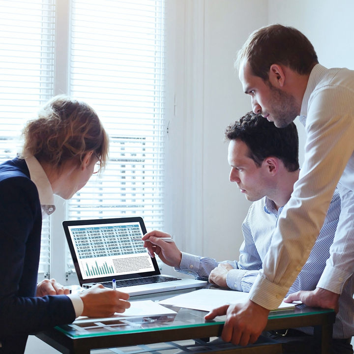 Japanese alt text: 数値を確認する3人