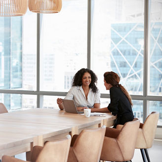 テーブルの角に座り話す二人の女性