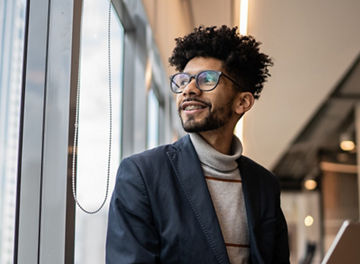 Businessman contemplating in the office looking through the window