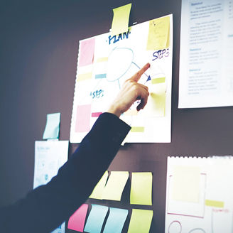 Japanese alt text: 掲示物を指さす女性