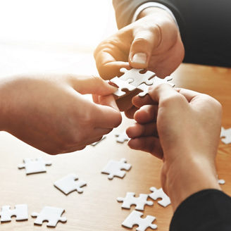 Group of Business people hands are holding and conecting jigsaw puzzle on desk and solving puzzle together at meeting in the office. Assembling, Solutions, Success and Strategy concept.