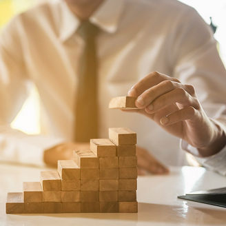 Japanese alt text: ブロックを重ねるビジネスマン