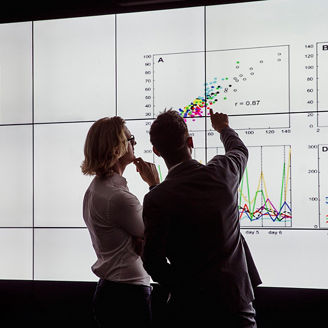 グラフを指さす男性と考える女性