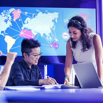 世界地図の前で打ち合わせをするひとびと