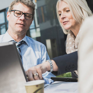 PCを見ながら意見交換する男女