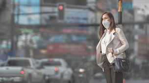 Asian woman are going to work.she wears N95 mask.Prevent PM2.5 dust and smog