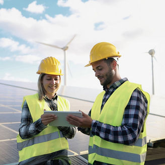 Japanese alt text: タブレットを見ながら相談する2人の作業員