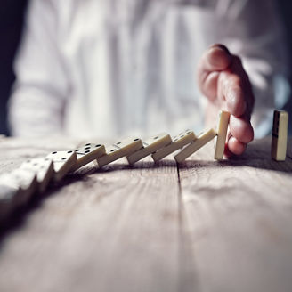 Japanese alt text: ドミノを止める手