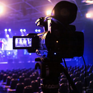 Japanese alt text: スポットライトを浴びたステージを映すカメラ