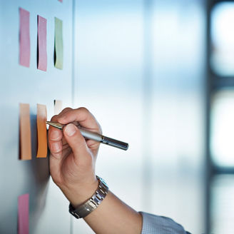 壁に貼った付箋に書き込む人