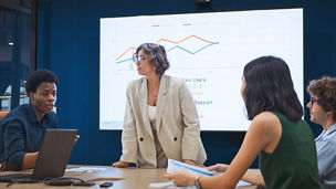 Group of gen z multiethnic businesspeople team meeting discussion in corporate office meeting room, presentation on TV screen. Workplace diversity, work life, team building, business people lifestyle