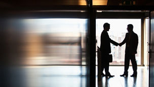Businessmen shaking hands in corridor