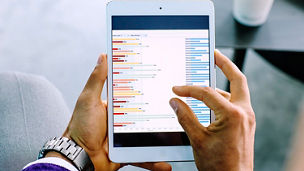 Mixed race businessman examining graph on digital tablet