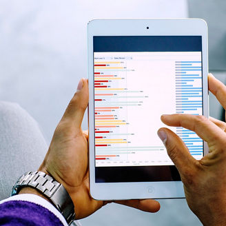 Mixed race businessman examining graph on digital tablet