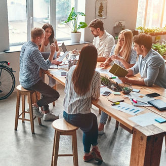 大きなデスクで一緒に仕事をするひとたち