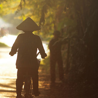 ベトナムの道を自転車で走行する人