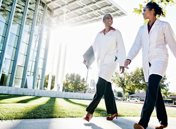 Doctors walking and talking outdoors at hospital