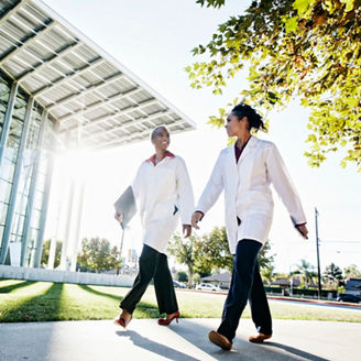 Doctors walking and talking outdoors at hospital