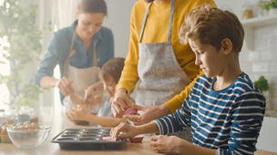 Kid making muffins with family