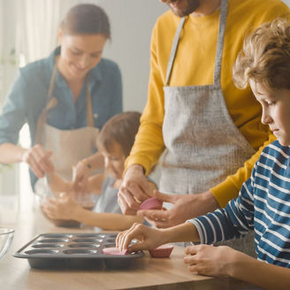 kind maakt muffins met ouders in de keuken