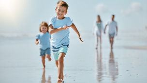 Kids, running and beach with a family on holiday or summer vacation together outdoor in nature. Children, travel and tourism with a brother and sister racing on the sand by the sea or ocean.