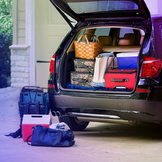 Auto in Einfahrt mit offenem Kofferraum