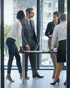 Kollegen in einem Büro stehen am Tisch