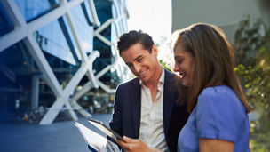 Two smiling finance professionals using KPMG Finance Hub