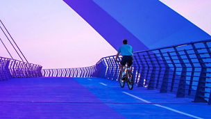 Mann mit Fahrrad auf der Brücke