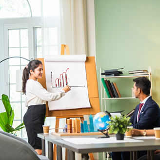 Confident Indian asian male or female boss or trainer make whiteboard presentation at team office meeting